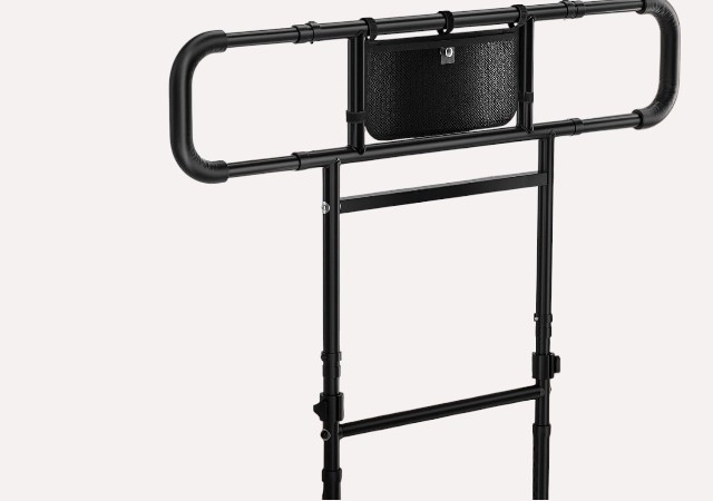 FORTEMOTUS foldable and extendable bed rail installed on a king-size bed, featuring a black carbon steel frame for elderly safety and bedside support.