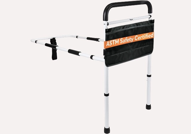 "Vaunn Medical bed assist rail with foam-padded hand guard, shown beside a twin bed for safe entry and exit, tool-free setup for adult use.